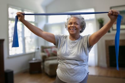 An elderly woman uses exercise bands to prevent and manage osteoporosis