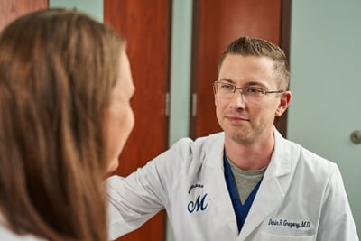 Dr. Gregory, a Moreland OB-GYN doctor, talks with a patient in an exam room as they discuss diagnosing vaginal dryness