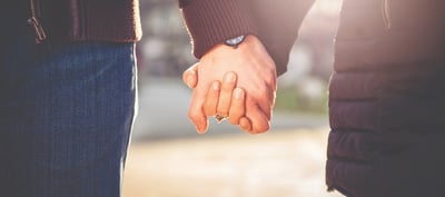 Couple going through fertility testing holding hands