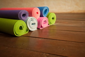 colorful yoga mats piled up, used for relieving pain from menstrual cramps