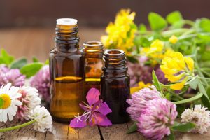 bottles of essential oils that are safe for pregnancy surrounded by flowers