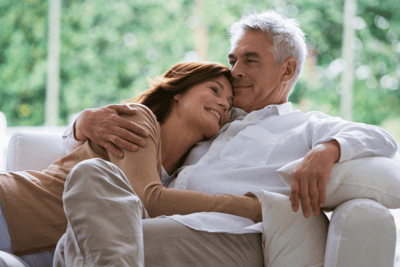 Midlife couple cuddling on couch