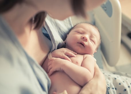 Mother holding newborn baby boy in her arms