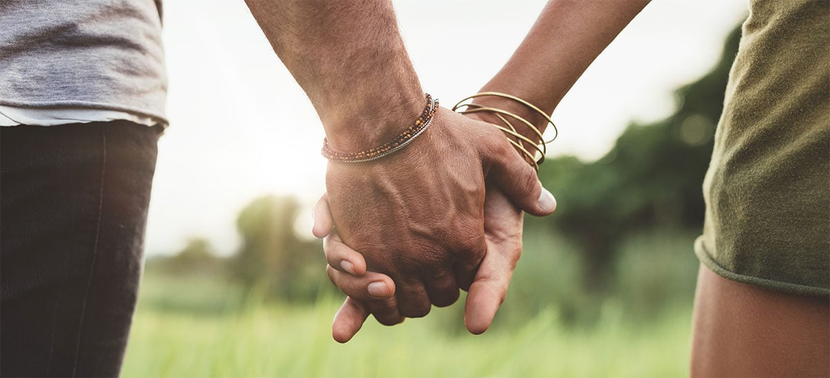 Young-couple-holding-hands-in-the-field