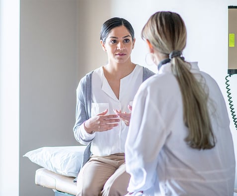 female-patient-sits-on-the-examination-table-at-her-gynaecologists-office